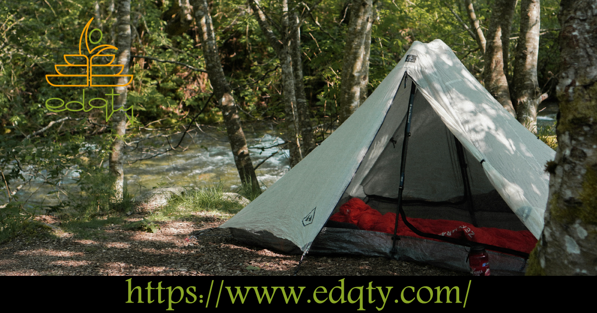 A tent set up by a serene riverside symbolizing the hands-on experiences that foster independence